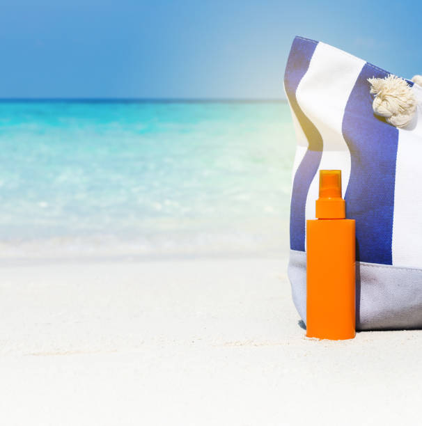 istock Sunscreen lotion and blue stripe bag on beach 1044473180