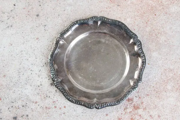 Vintage silverplate dish on concrete background. Copy space for text.