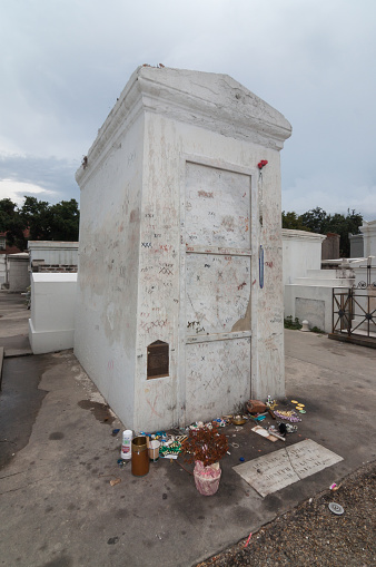 New Orleans, USA - Jul 28, 2009: Late in the day at Saint Louis Cemetery No. 1. The Voodoo priestess Marie Laveau grave covered with xxx by visitors as well as items left behind as offerings.