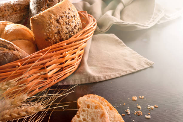 istock Basket with bread on fabric and black wooden table 1044492794