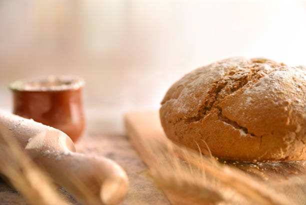 Bread loaf homemade with kneader and flour on black table in the kitchen. Front view. Horizontal composition