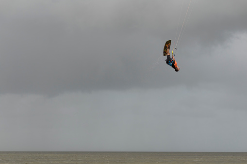 CANCUN, MEXICO - 01/30/2018: Mexican athlete trains for kitesurf competition on a cloudy morning. Kitesurf or kiteboarding allows him to fly in the air.