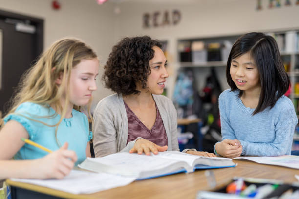 istock Teacher helping 4th graders in her classroom 1044495556