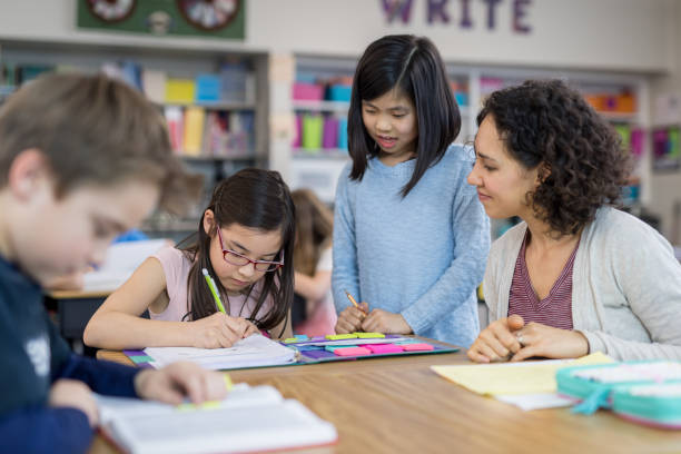 istock Teacher helping 4th graders in her classroom 1044495566