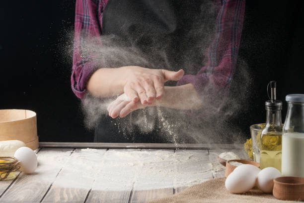 istock The chef sprinkles the flour on the surface. Black background 1044501496