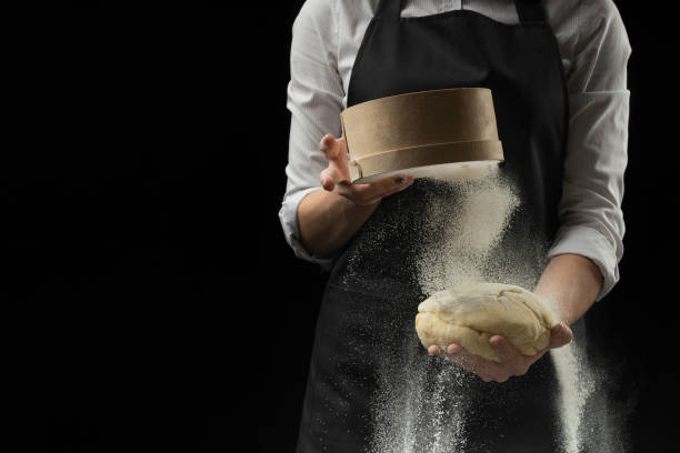 istock Chef cooked dough for pizza, rolls, pasta on a dark background. Baker's bakery 1044501582