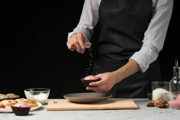 istock Chef prepares chocolate muffins on a dark background 1044511432