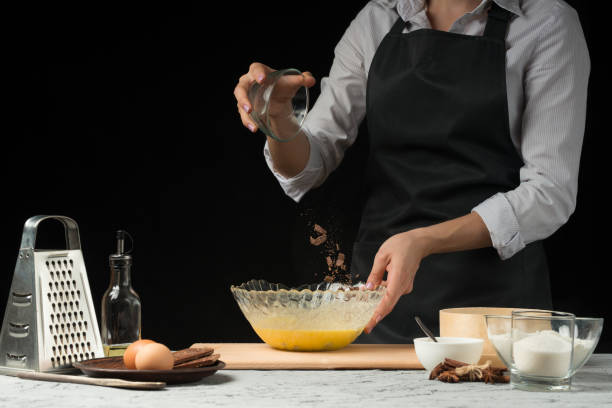 istock Chef cooks dough for sweets on a dark background 1044511502