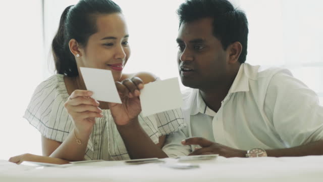 Asian couple looking at photo while honeymoon time with love emotion