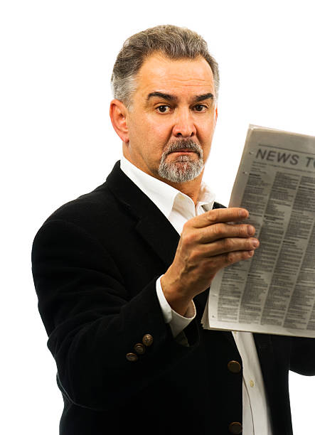 istock Mature man holds a newspaper, looking serious. 104452616