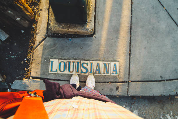 Photo of a person, looking down at a street sign in the road that says \