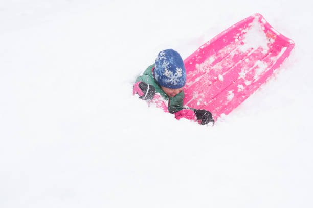 istock Children happy and playful while joyfully sledding during a big snow storm 1044528136
