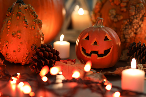 Halloween, autumn scene with pumpkins.  Group of objects includes: candles, pumpkins, jack o' lanterns, fall leaves, and pine cones.
