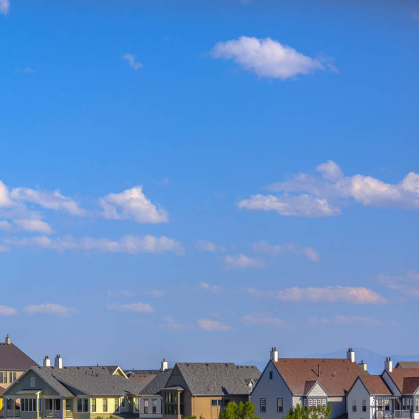istock Sunlit houses with boundless blue sky above 1044535866