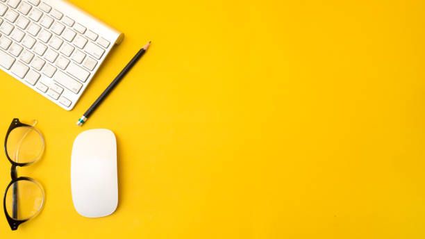 istock Office desk table Top view with keyboard copy space yellow background 1044538478