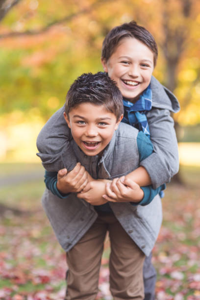 istock Two elementary-age boys walk to school through the park 1044538780