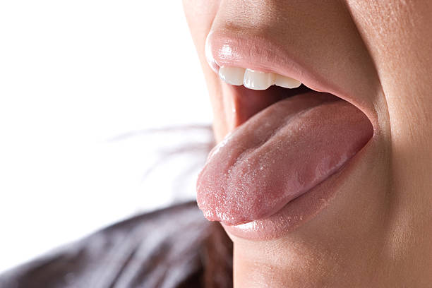 close-up of woman sticking out her tongue - mensentong stockfoto's en -beelden