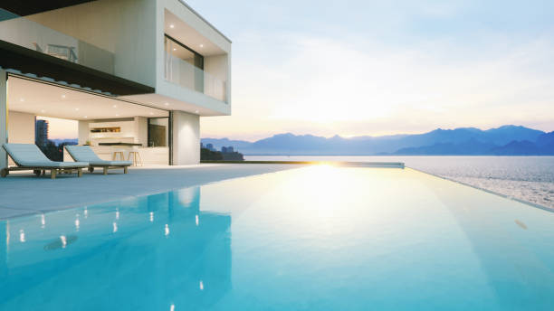 Luxury Holiday Villa With Infinity Pool At Sunset Modern luxury house with infinity pool over the ocean at sunset. villa stock pictures, royalty-free photos & images