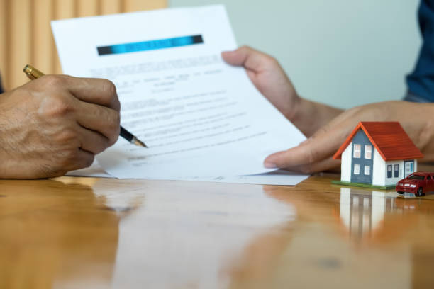 Hands holding small house after signing contract,concept for real estate,Insurance and safety concept with house protected by hands, moving home or renting property stock photo
