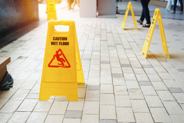 istock caution wet floor warning sign with blurred people walking 1044583148