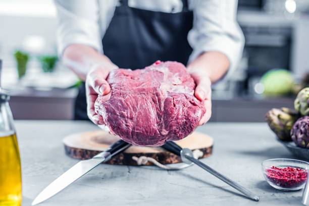 chef de cocina restaurante cocina, él es cortar carne o bistec - round of beef fotografías e imágenes de stock