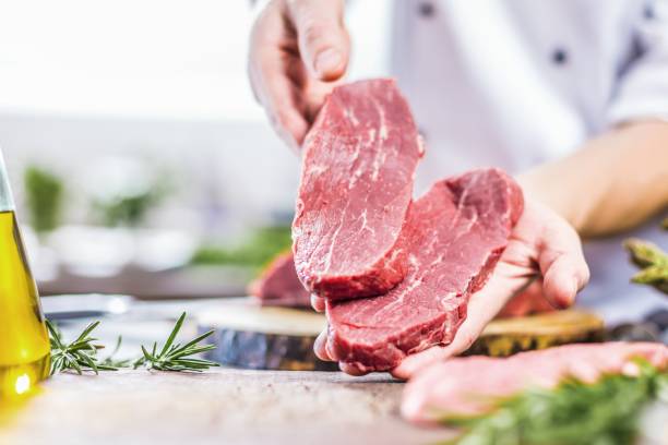 istock Chef in restaurant kitchen cooking,he is cutting meat or steak 1044597394