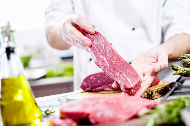 istock Chef in restaurant kitchen cooking,he is cutting meat or steak 1044597732