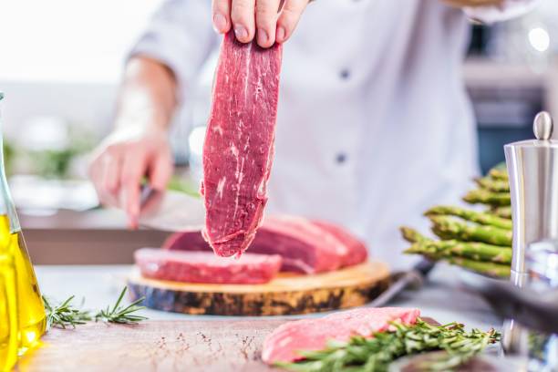 istock Chef in restaurant kitchen cooking,he is cutting meat or steak 1044599820