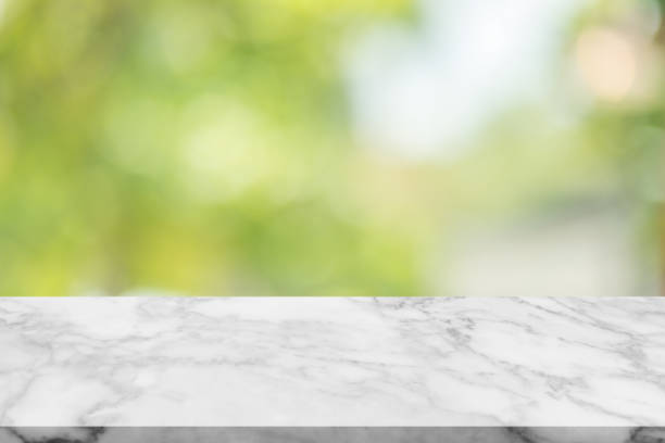 istock White marble stone table top on blur green background from nature 1044611360