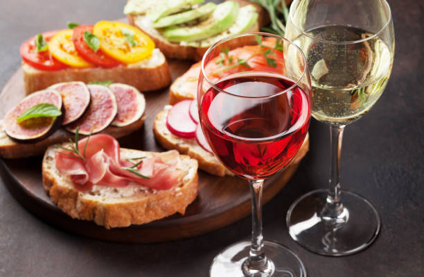 Rose and white wine with Brushetta or traditional spanish tapas. Appetizers italian antipasti snacks set on wooden board