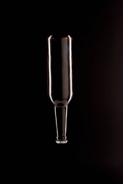 istock beer bottle upside down isolated on black background, minimalistic concept 1044637096