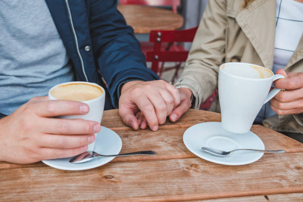 istock couple holding hands while drinking latte in outdoors cafe 1044639894