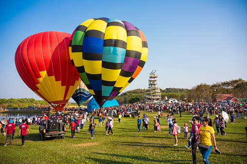 Colorful hot air balloon flying over a blue sky with white clouds