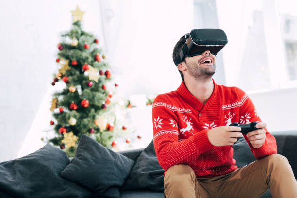 istock excited man playing game with virtual reality headset and joy pad on christmas eve 1044646020