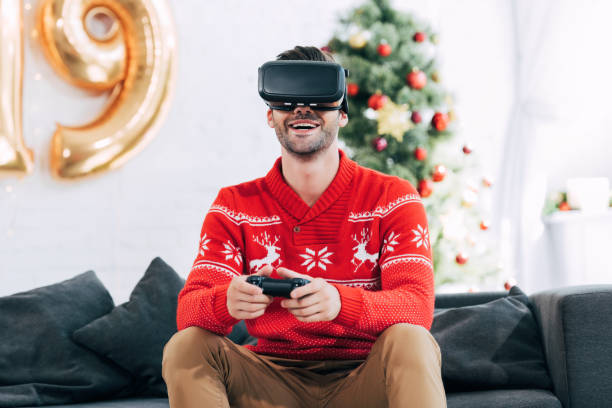 istock happy man with virtual reality headset and joy pad playing video game during 2019 new year 1044646052