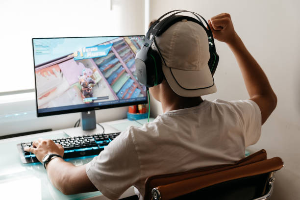 teenager playing fortnite video game on pc - online game imagens e fotografias de stock