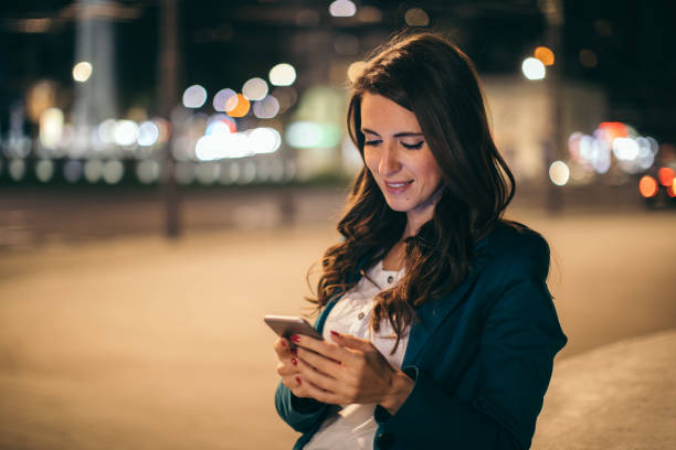 istock Young woman working outdoor while using cell phone 1044660750