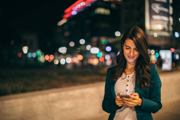 istock Young woman working outdoor while using cell phone 1044660756