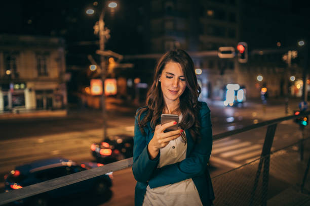 istock Young woman working outdoor while using cell phone 1044663210