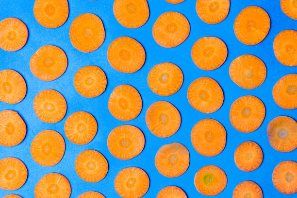 istock Carrot slices on blue background flat lay 1044678916