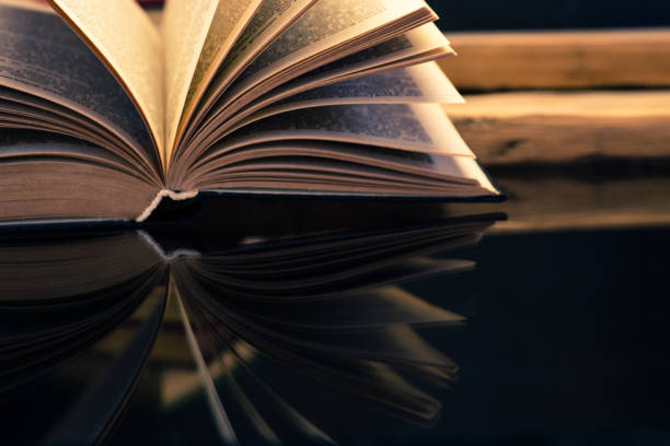 istock Old book on a oak wooden table. Beautiful dark background. 1044681578