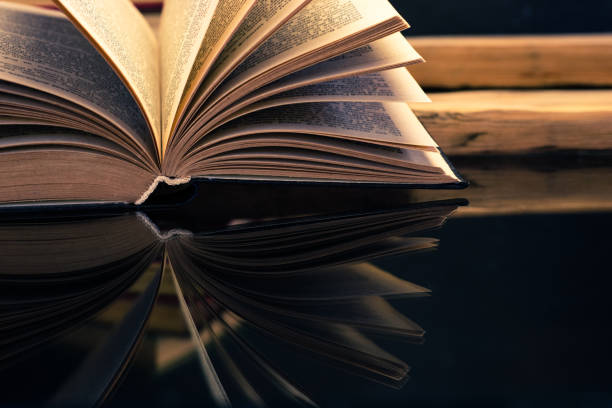 istock Old book on a oak wooden table. Beautiful dark background. 1044681870