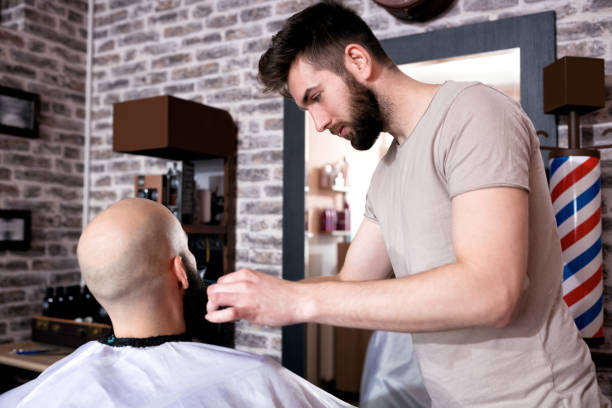 istock Professional Master hairdresser cuts client beard 1044685398