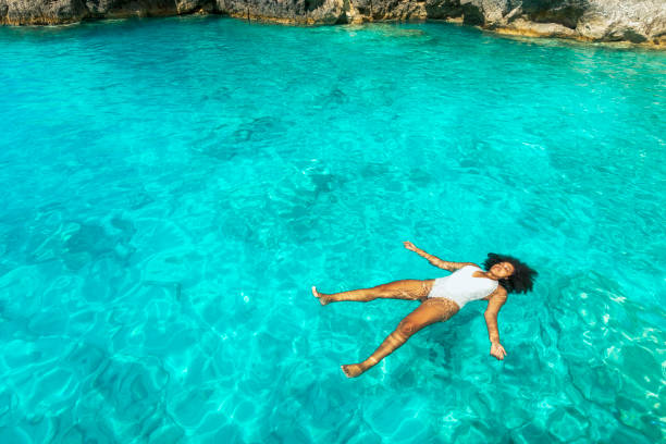 水に浮かぶのアフリカの女性 - sea swimming greece women ストックフォトと画像