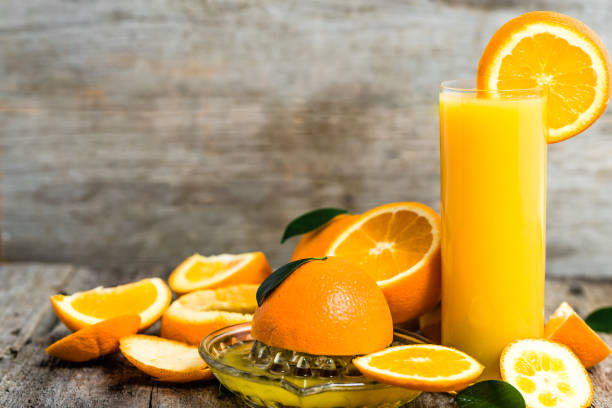 istock Squeezed orange juice and fresh oranges fruits on rustic wooden table 1044688940