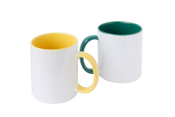 istock Two white mugs, with a green and yellow handle 1044697800