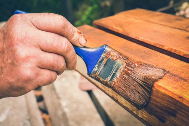 istock Painter with paintbrush painting wooden surface 1044704334