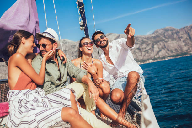 istock Smiling friends sitting on sailboat deck and having fun 1044711954
