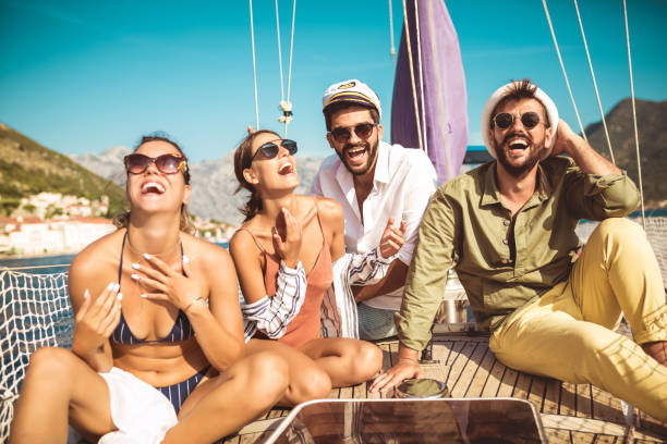 istock Smiling friends sitting on sailboat deck and having fun 1044712460