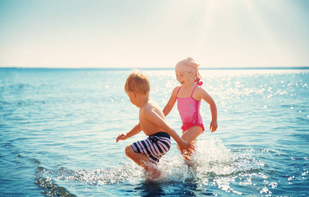 istock Boy and girl playing on the beach 1044715224